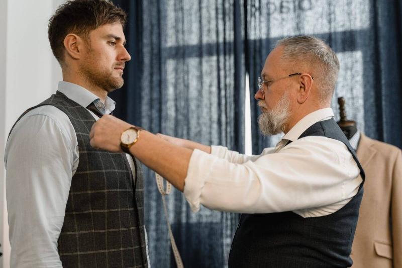 Old man measuring chest of young man.