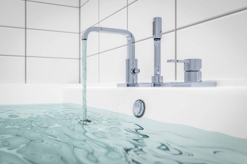A faucet filling a bathtub with water.