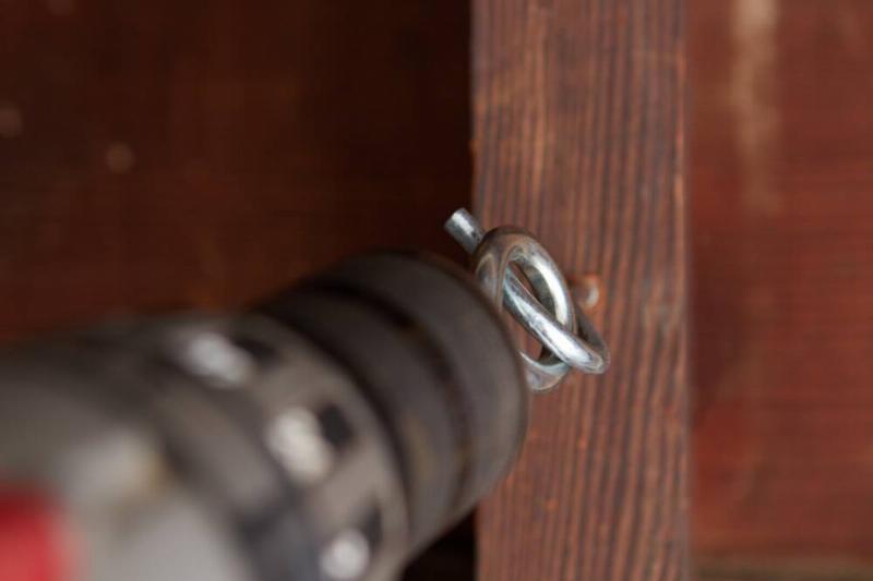 Using a second hook to drill the screw in.