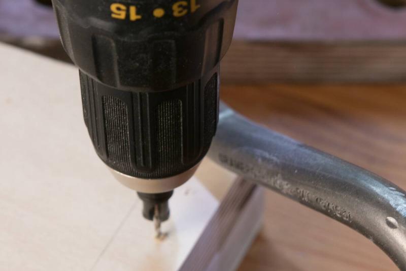 Drilling holes in the plywood.