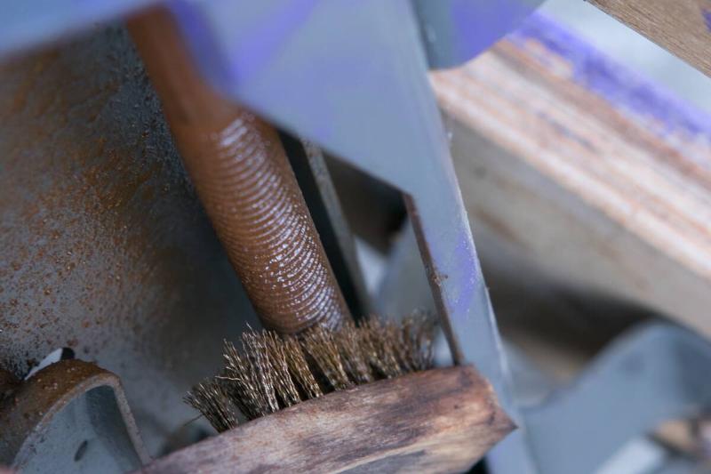 Using a brush to remove the rust. 