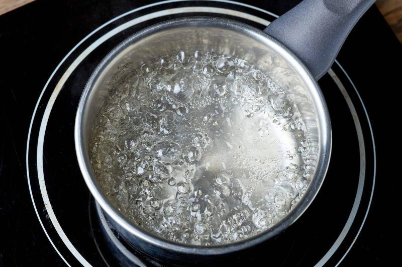A pot of water boiling on a stove.