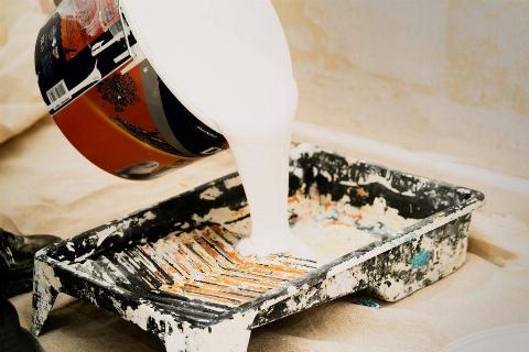 Paint being poured into a tray.