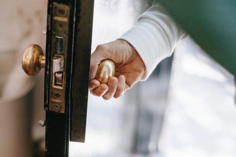 A hand opening a door.