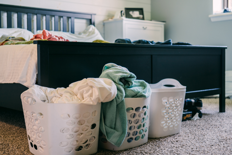 Sheets in washing bins at the foot of a bed. 