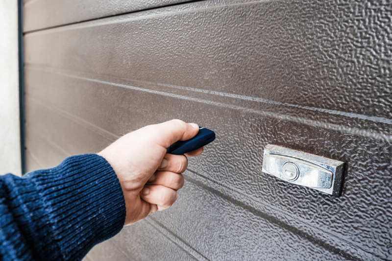 A hand holding a garage door opener.