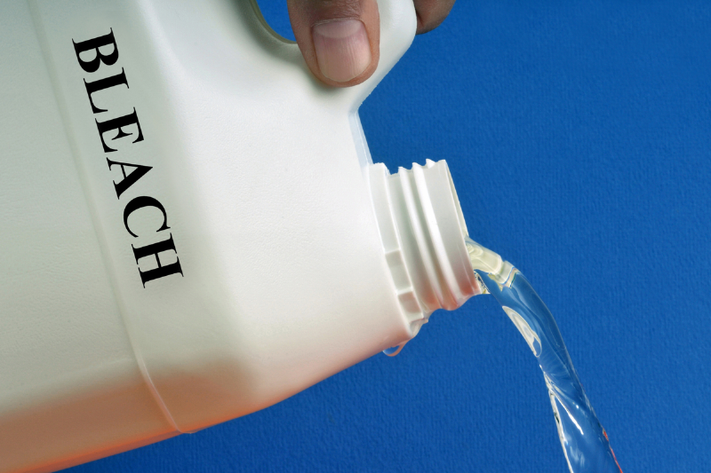 Pouring bleach from a bottle.