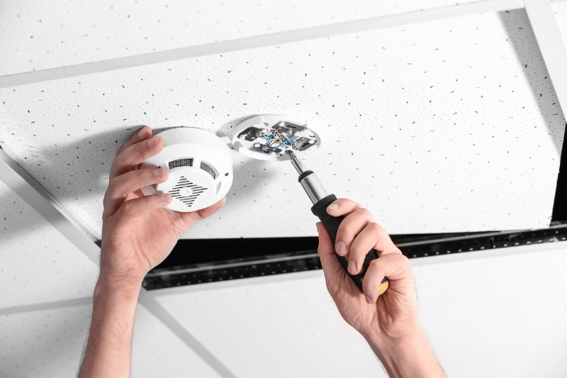 Person installing smoke alarm.