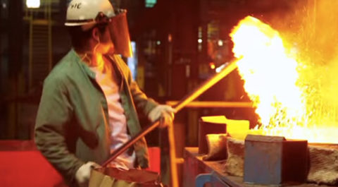 man pulling iron ore from melting pot