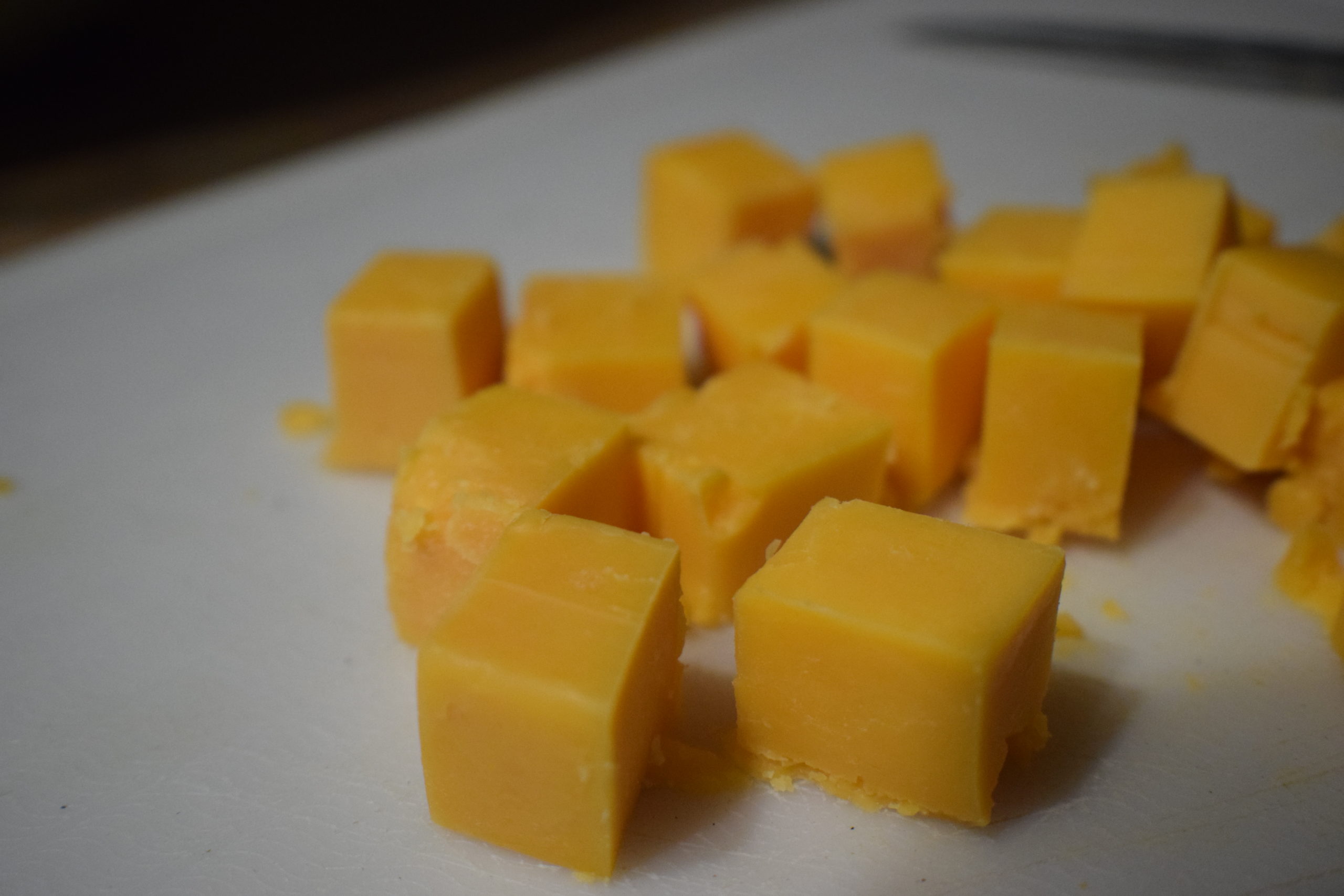 Cheddar cheese cubes on white plate