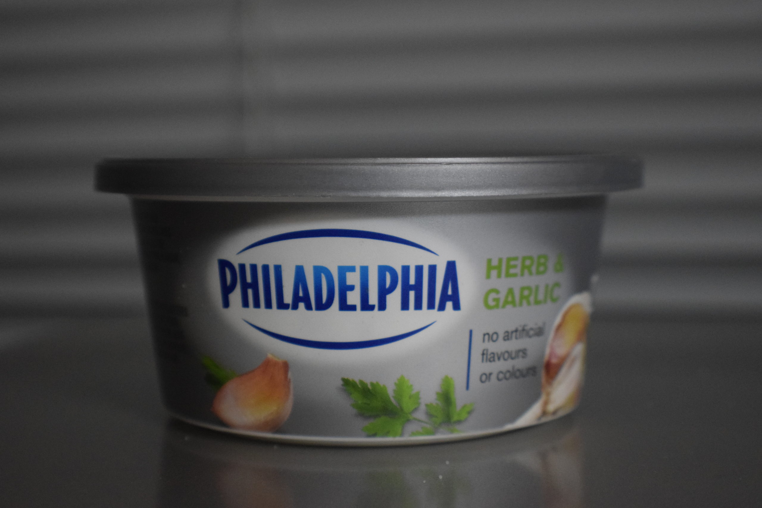 herb and garlic philadelphia cream cheese in front of blinds