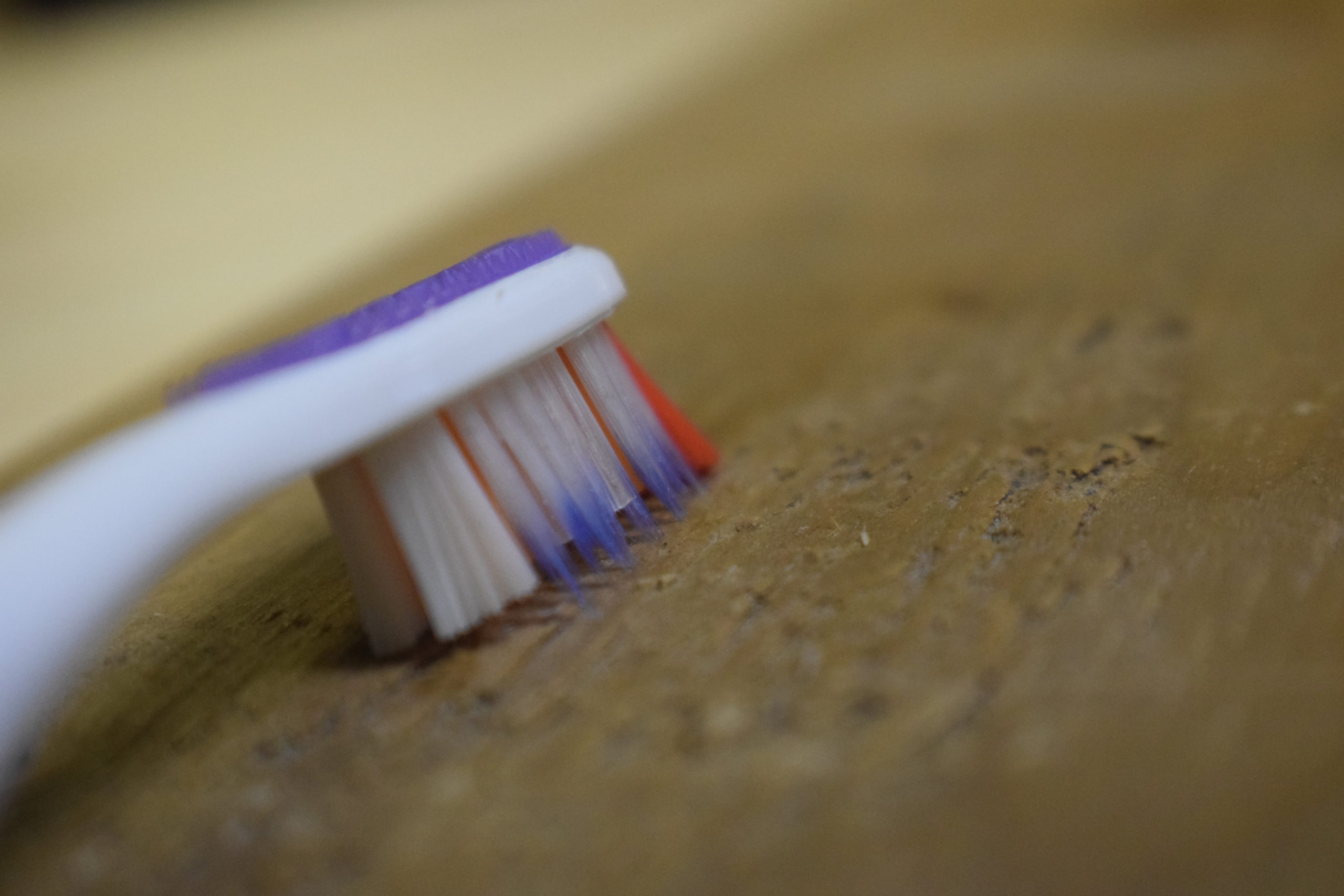 Purple toothbrush cleaning wood