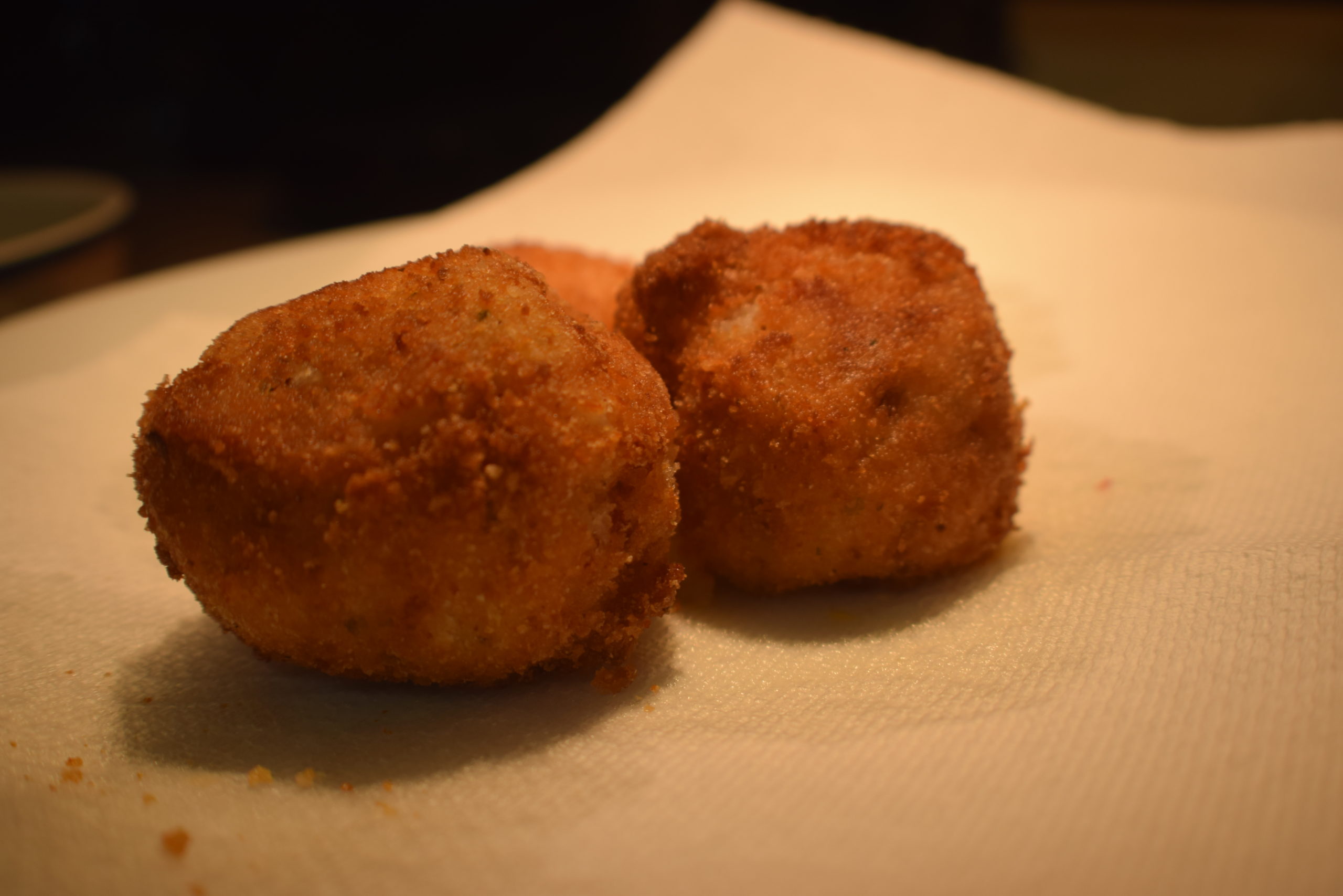 breaded potato balls on paper towel catching grease