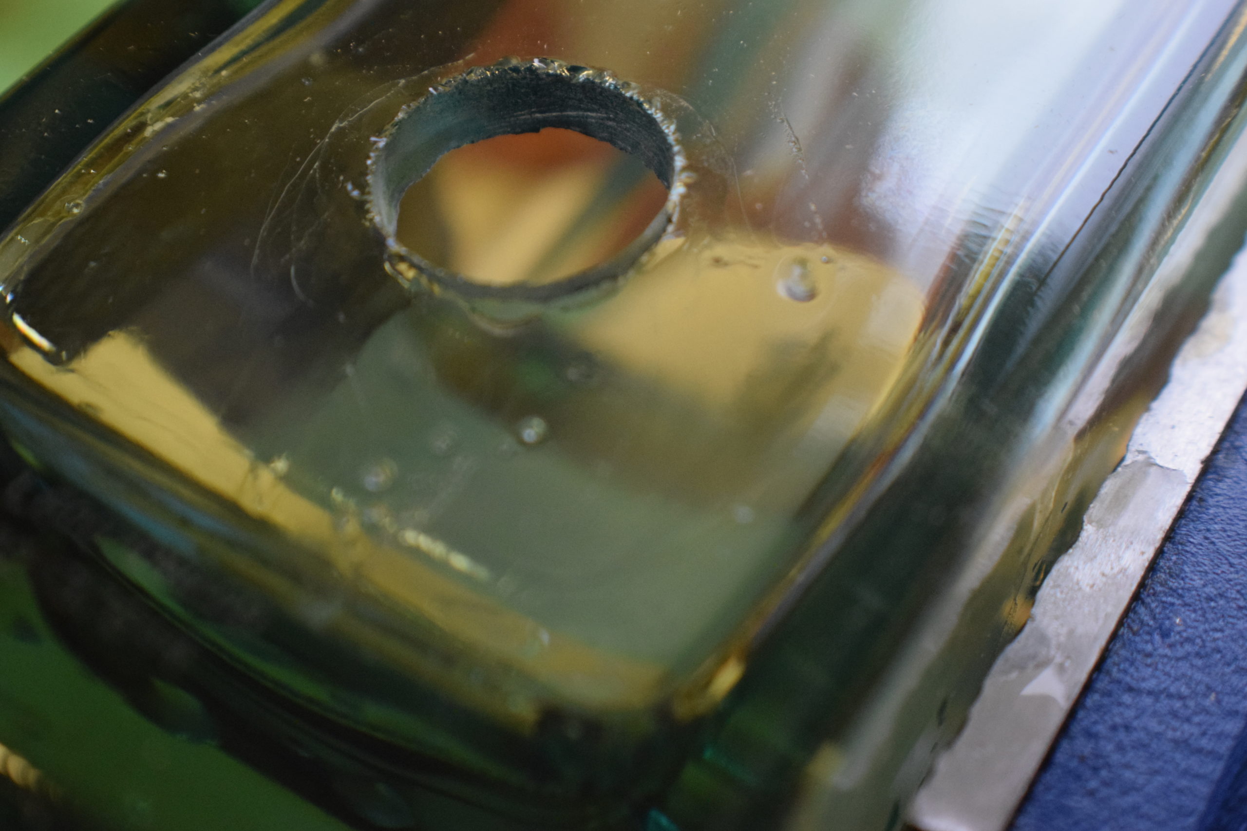 a hole drilled through square glass bottle.