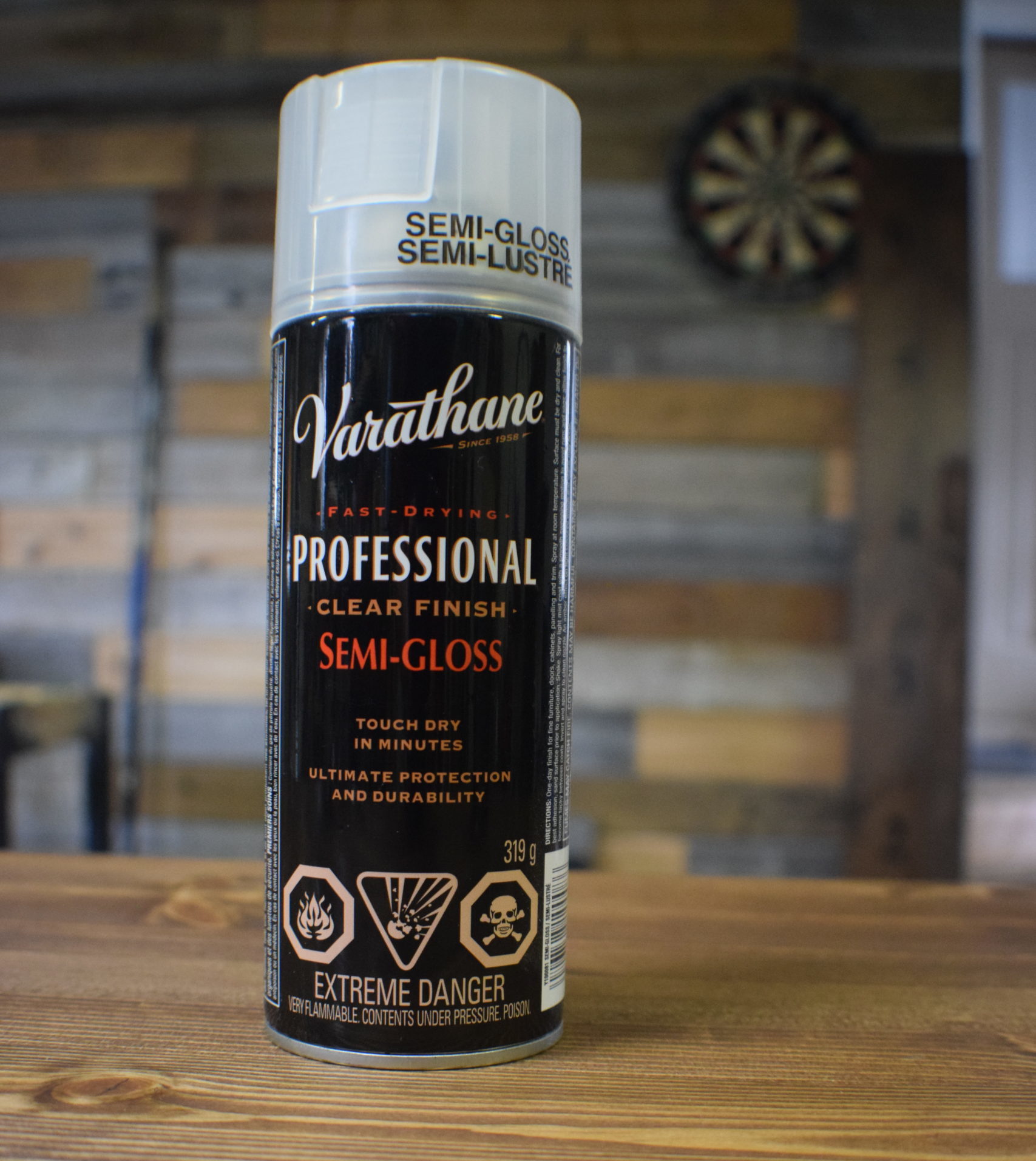 Spray can of varathane professional clear finish semi gloss with white and red text on wood background