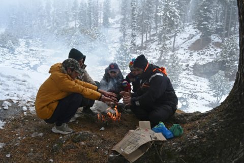 Family warming up beside fire