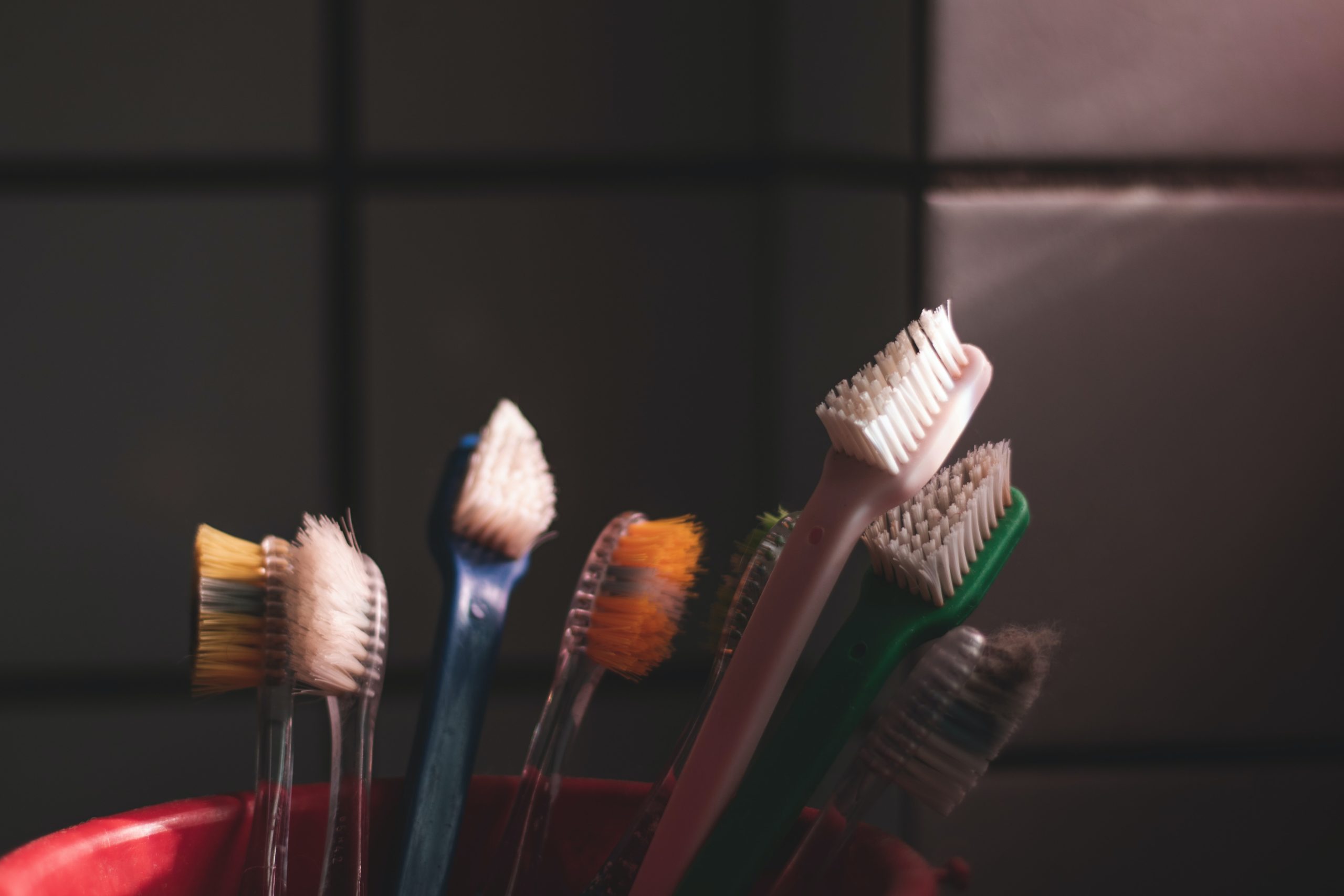 old toothbrushes stored together in dark space
