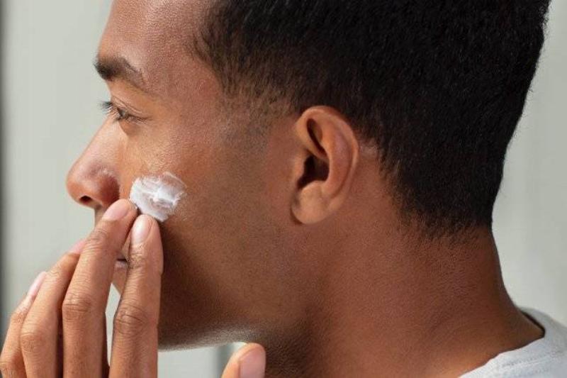 Man rubbing moisturizer into skin