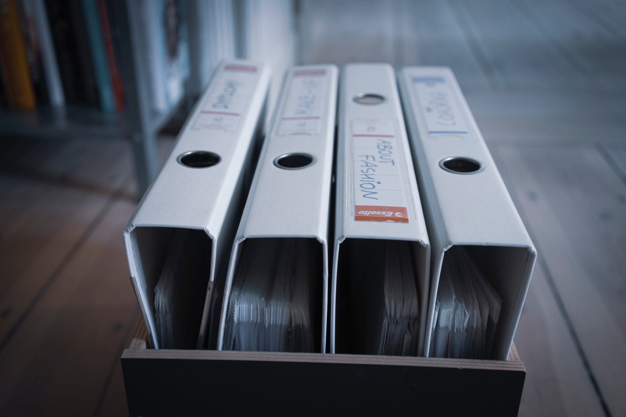 4 filled grey binders in a box 