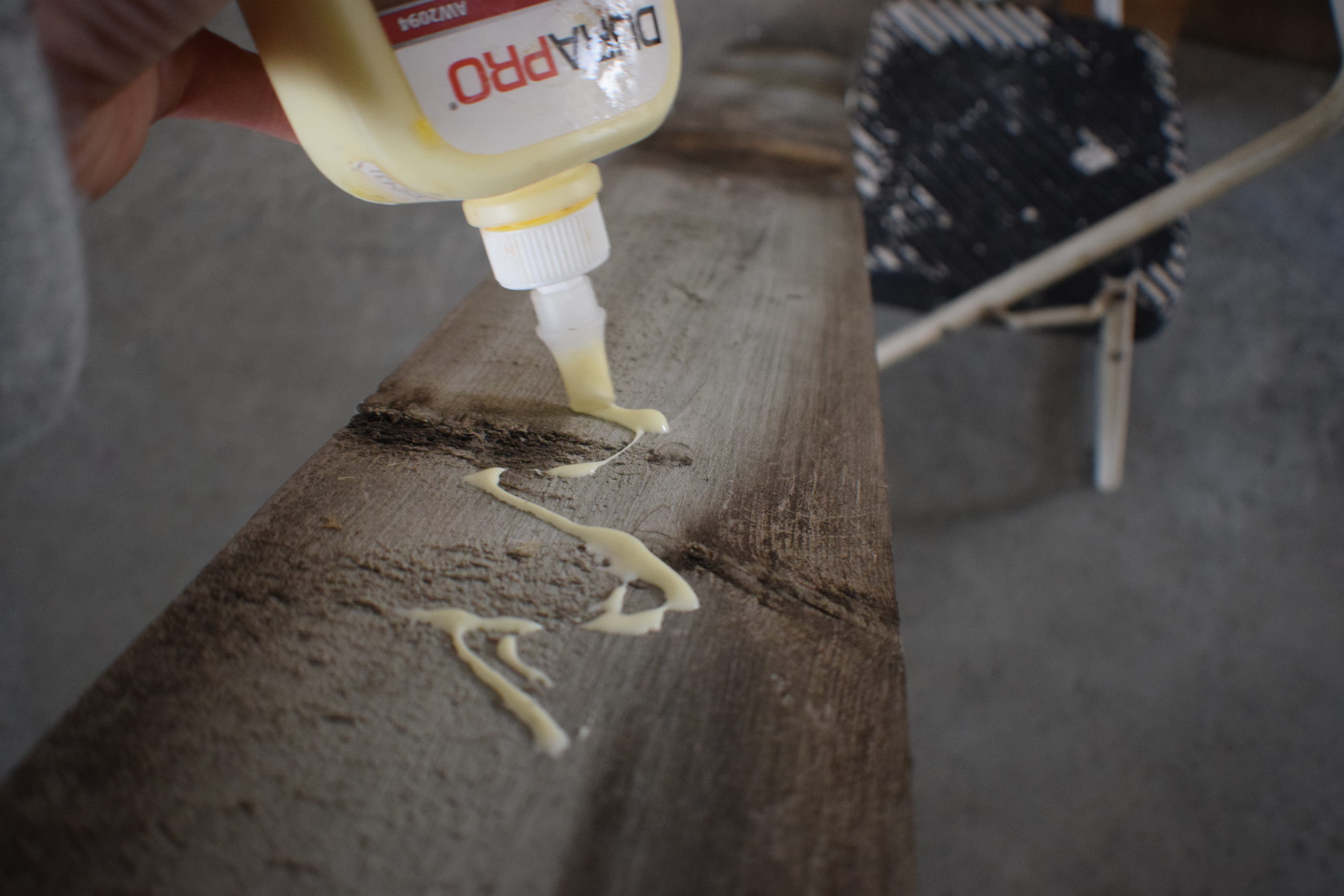 Wood glue being put on the back of a board in zig zag motion