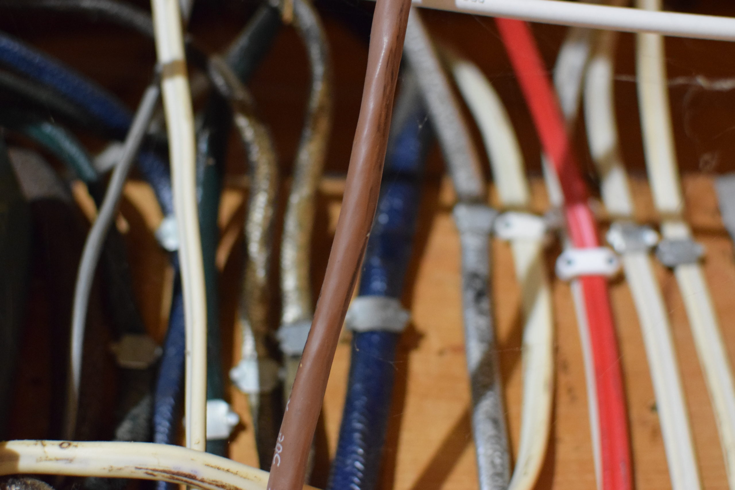 red, white, blue, brown and silver vertical electrical wires in utility room