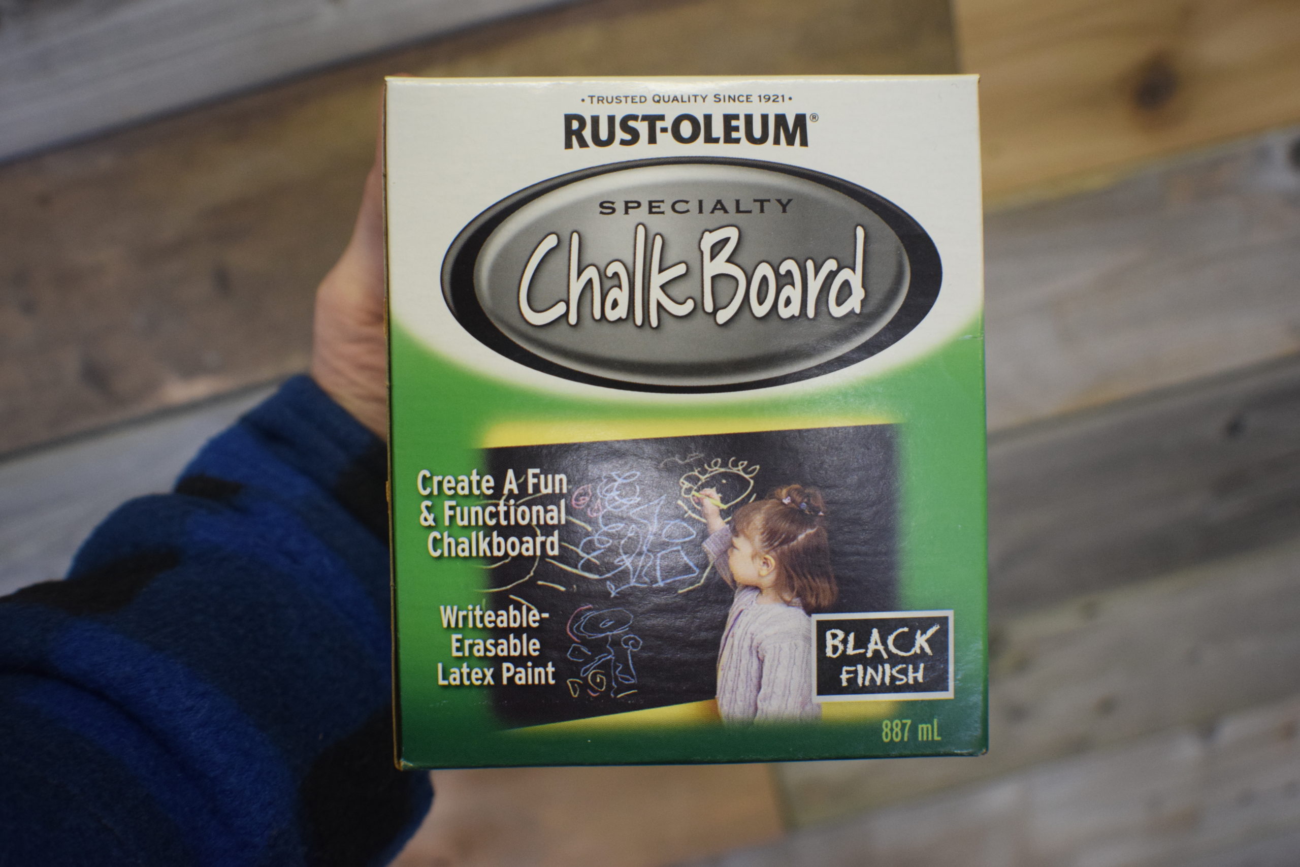 Box containing Rustoleum specialty Chalk Board paint in hand