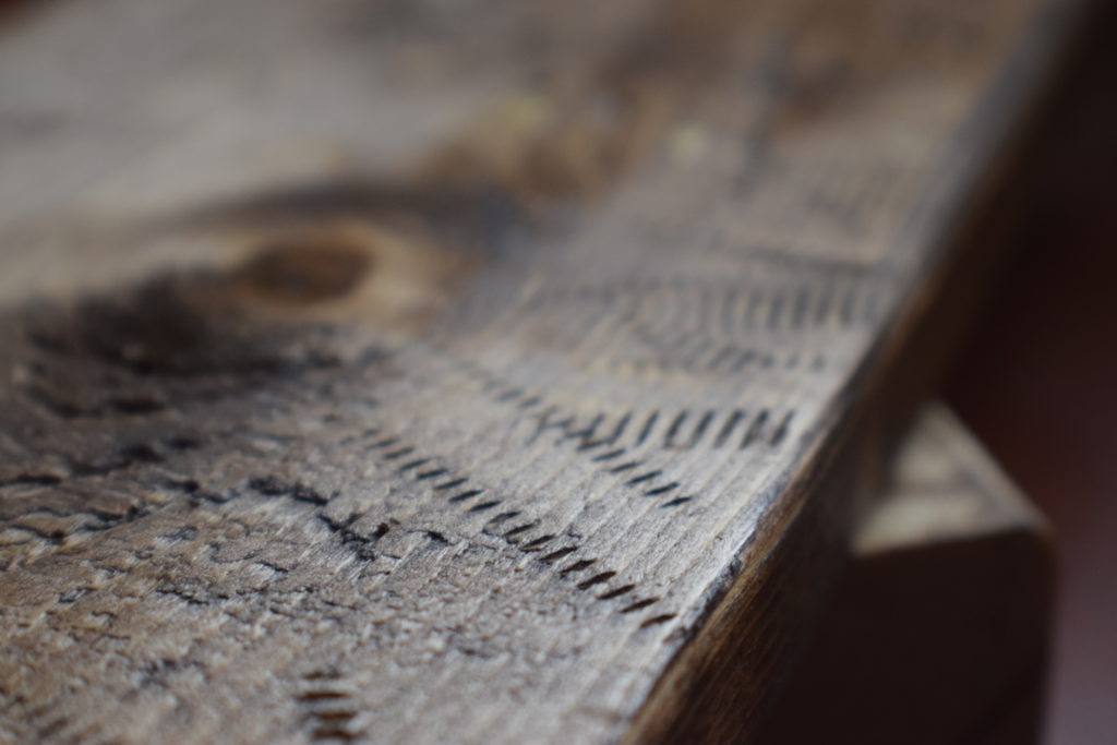 Weathered wood with screw markings stained brown