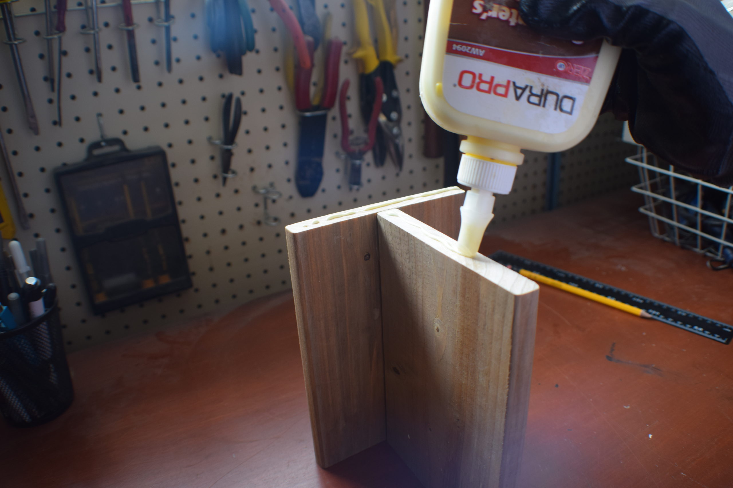 applying glue to t shaped wood in workshop