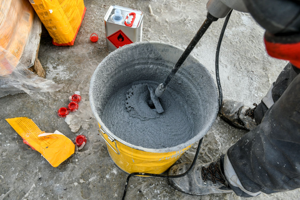 worker mixing concrete in bucket