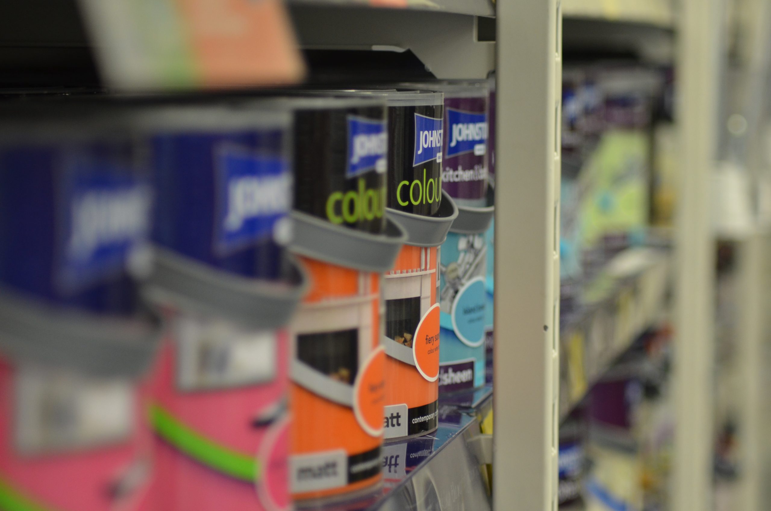 row of paint cans on hardware shelf