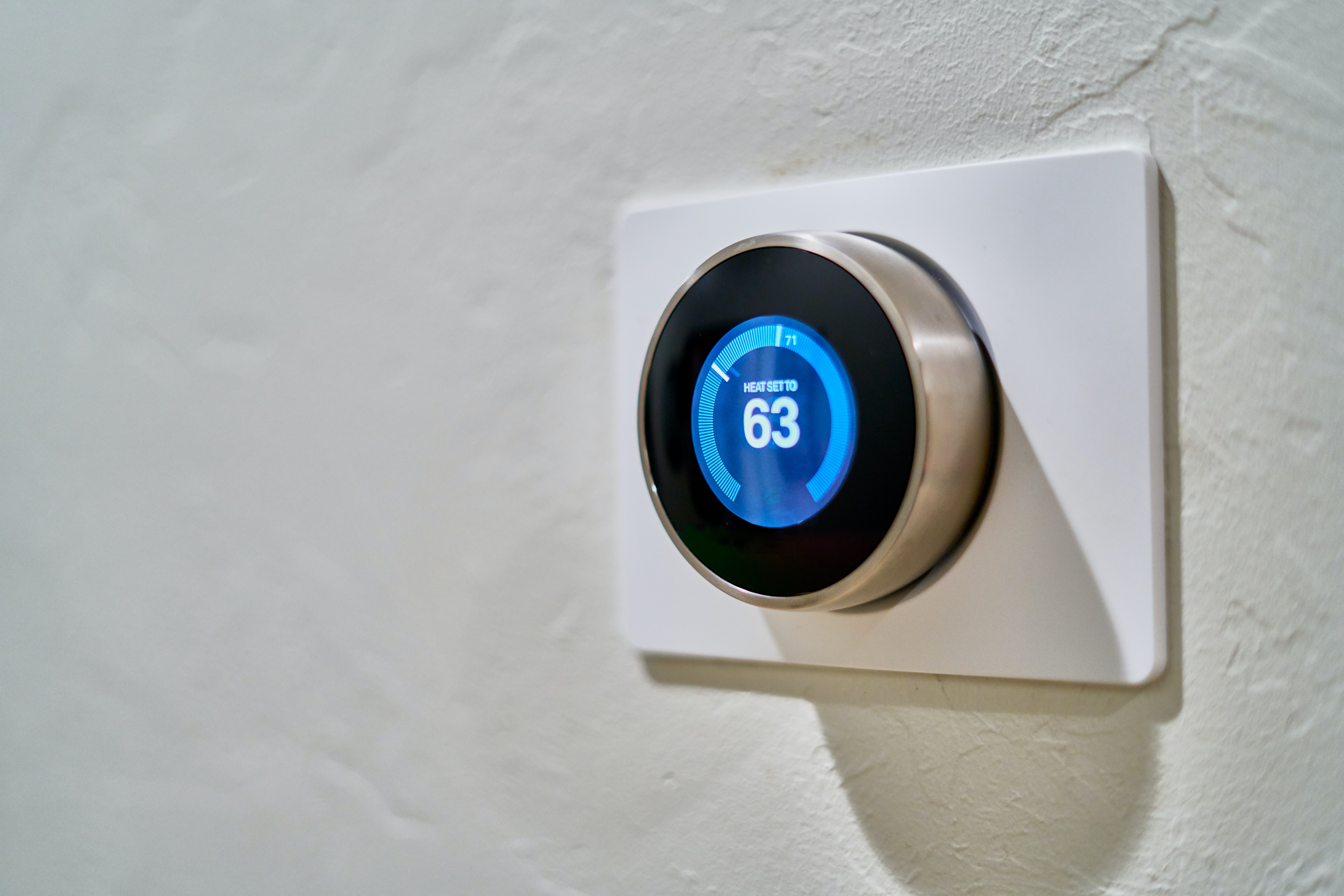 google nest thermostat on wall at 63 degrees