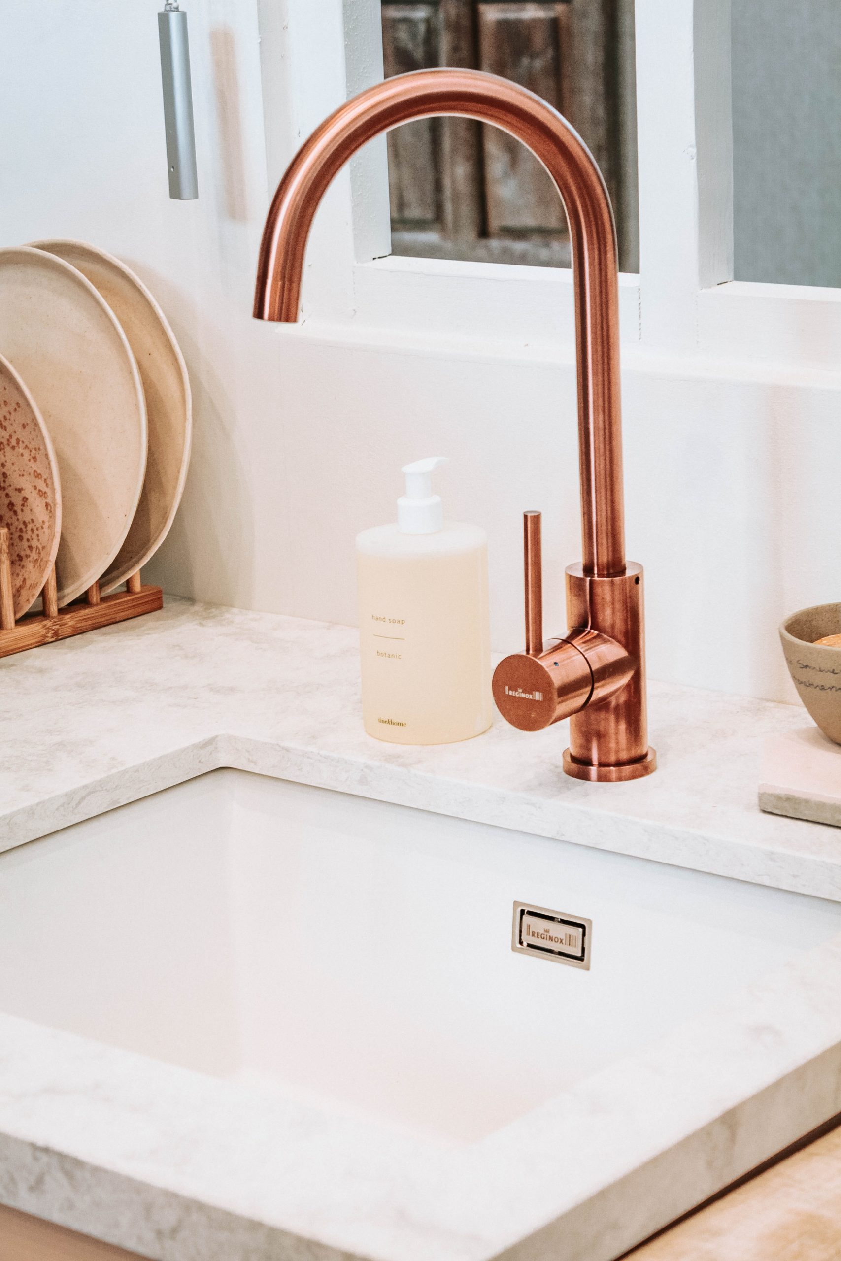 copper disc faucet in a white sink