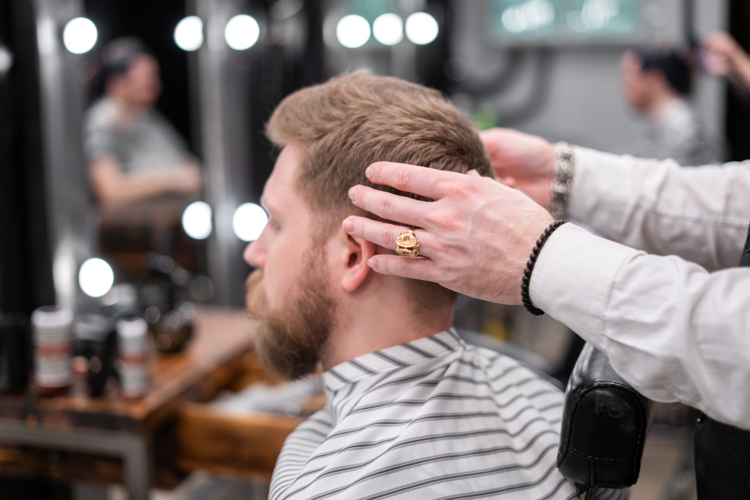 man with blonde hair and beard getting haircut