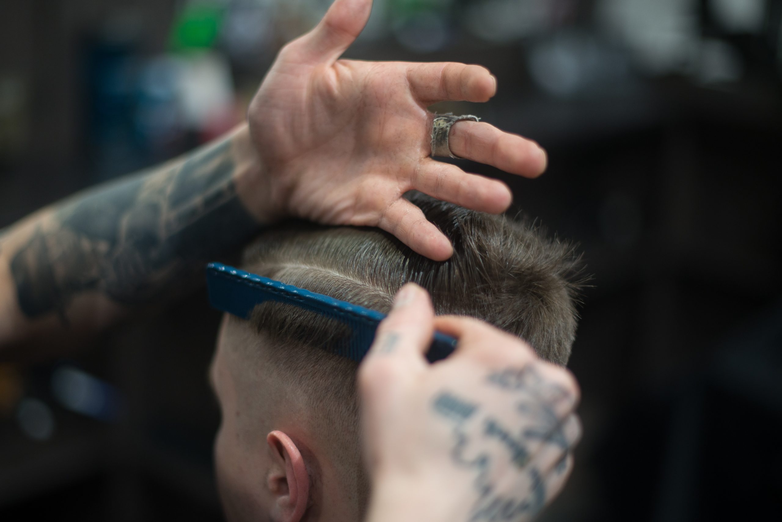 barber lining up haircut with comb