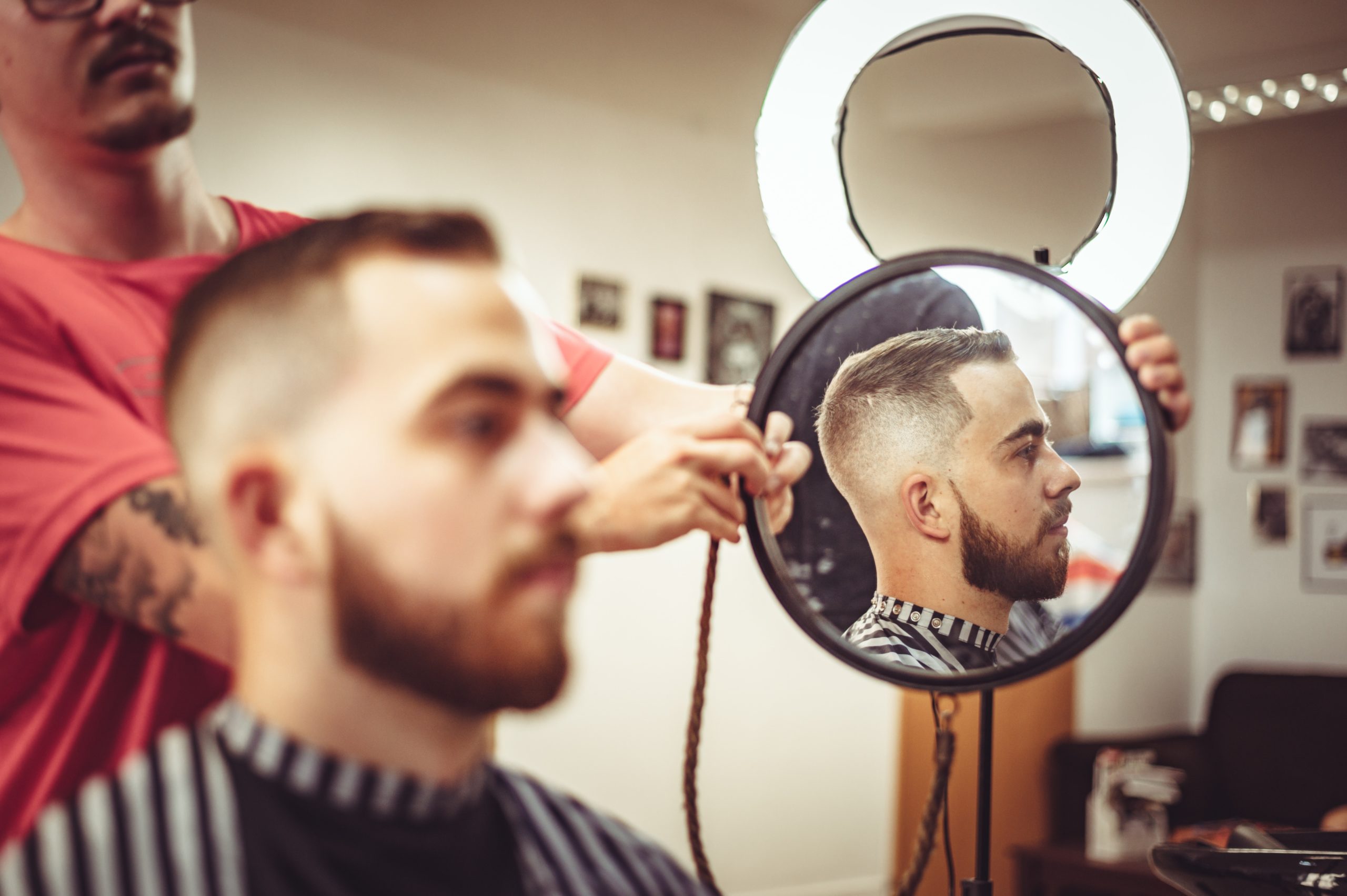 man being shown haircut through mirror