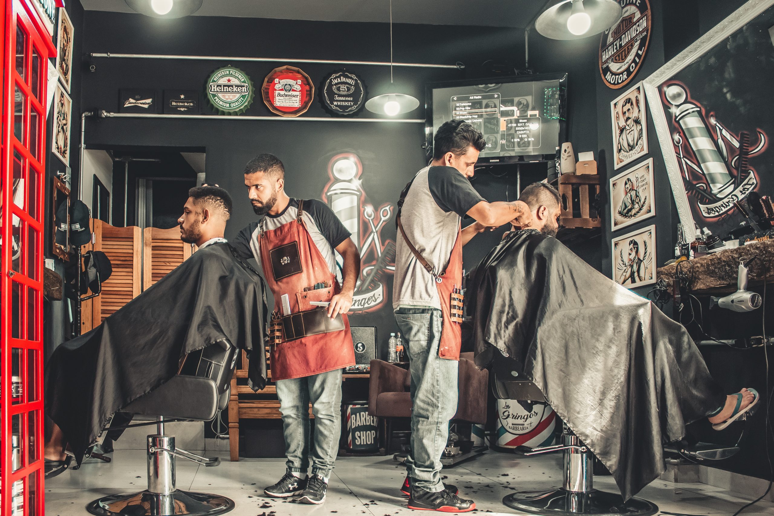 two barbers giving haircuts to two men