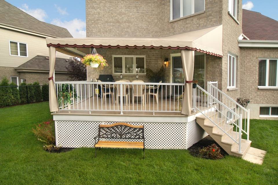 Backyard deck covered with beige sunshade