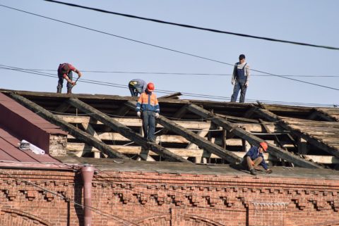 Men replace roof