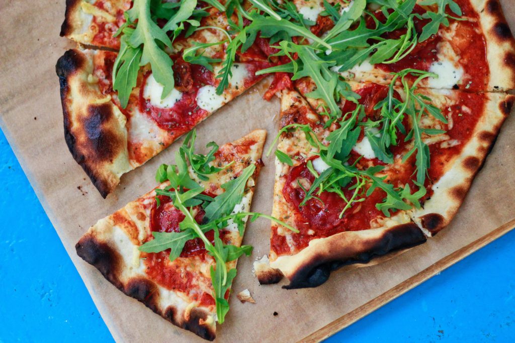 frozen pizza with fresh greens sprinkled on top