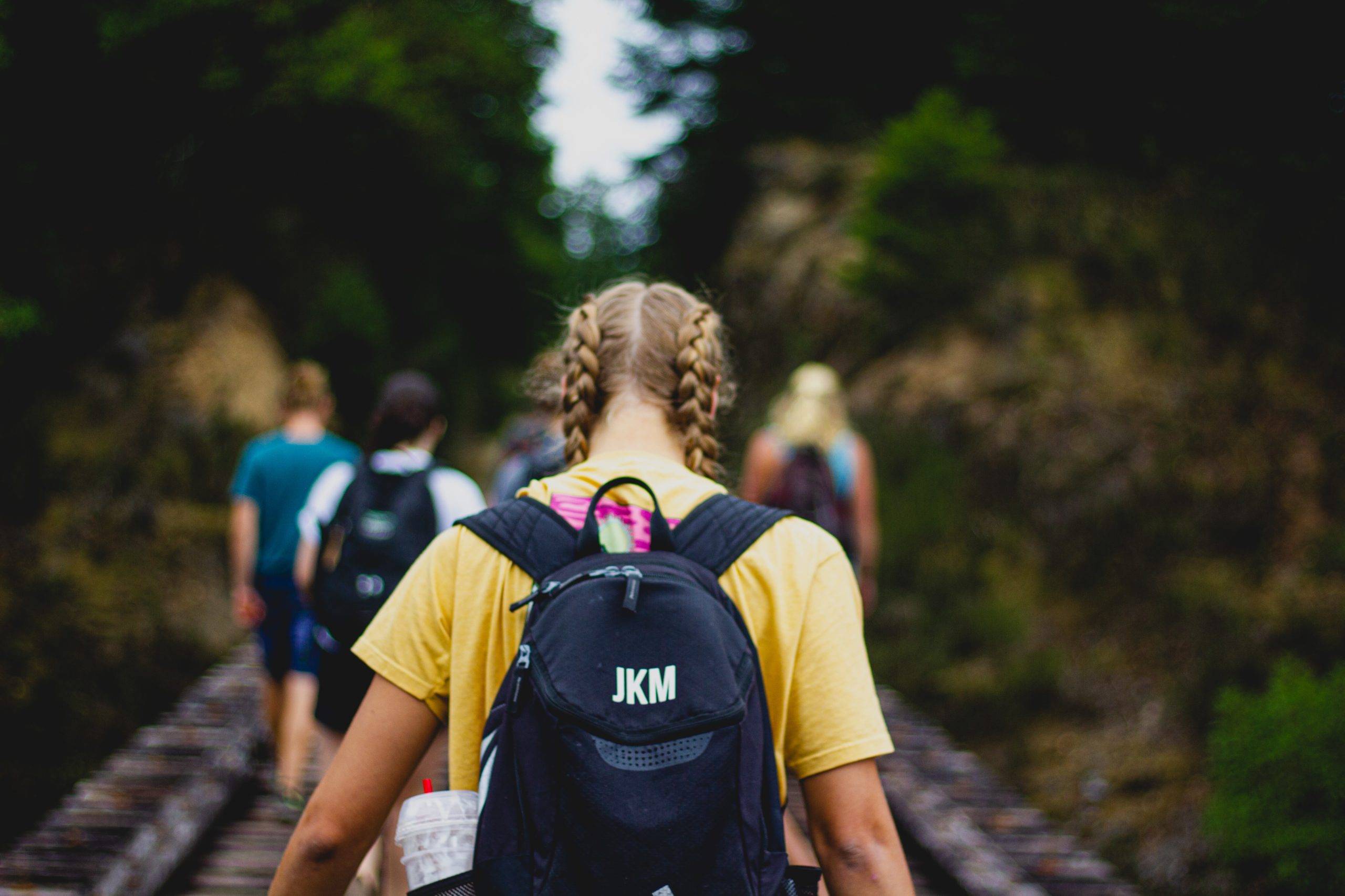 Girl with braided pigtails and black backpack