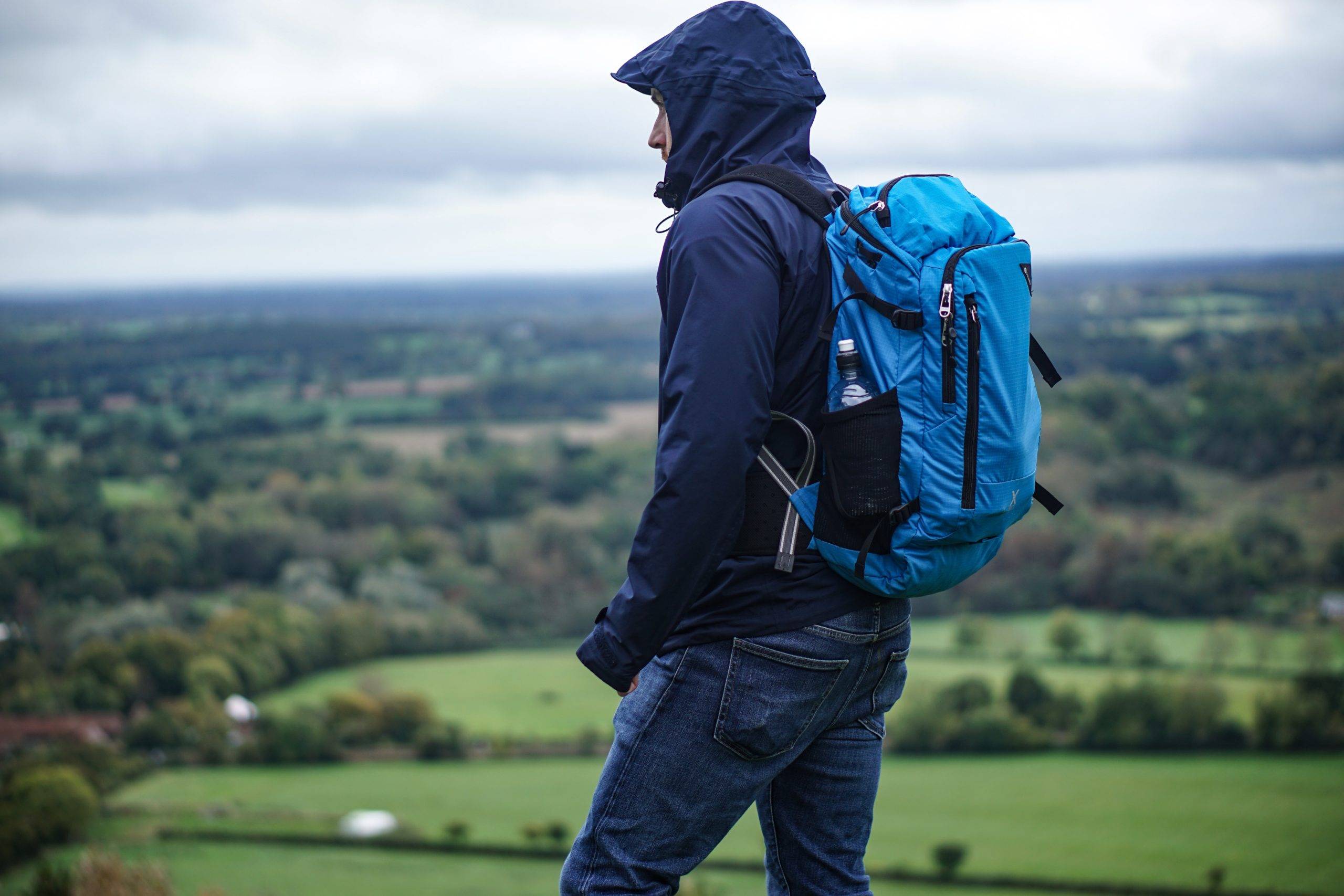 Man wearing hoodie with blue backpack