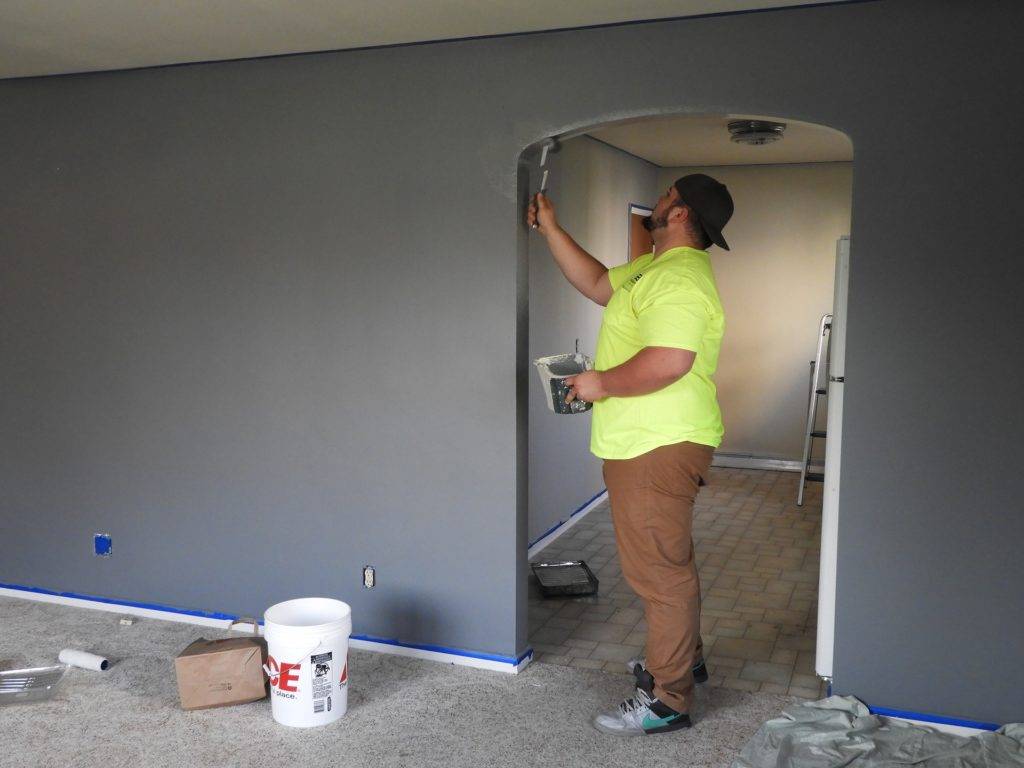 man painting doorway arch