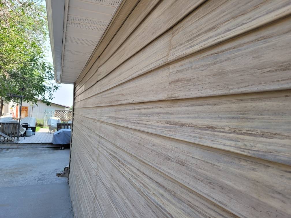 Vinyl siding of a house in light wood color.