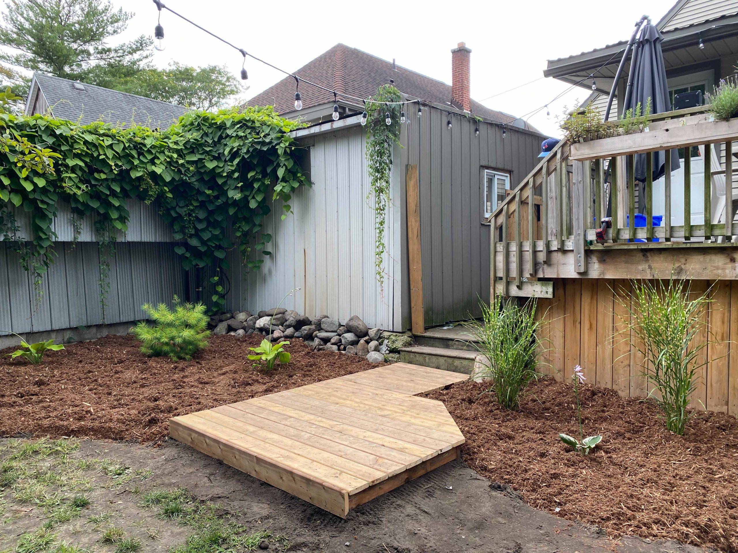 garden board walk in backyard with string lights