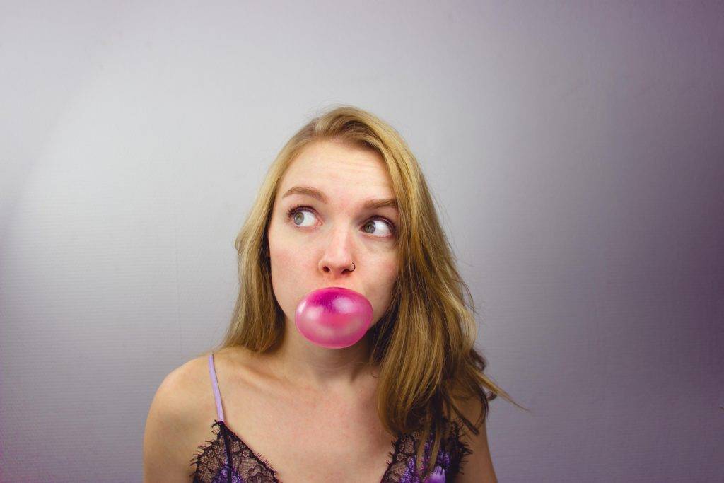 girl blowing a bubble with gum