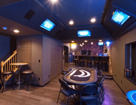 man cave with poker table and multiple tvs