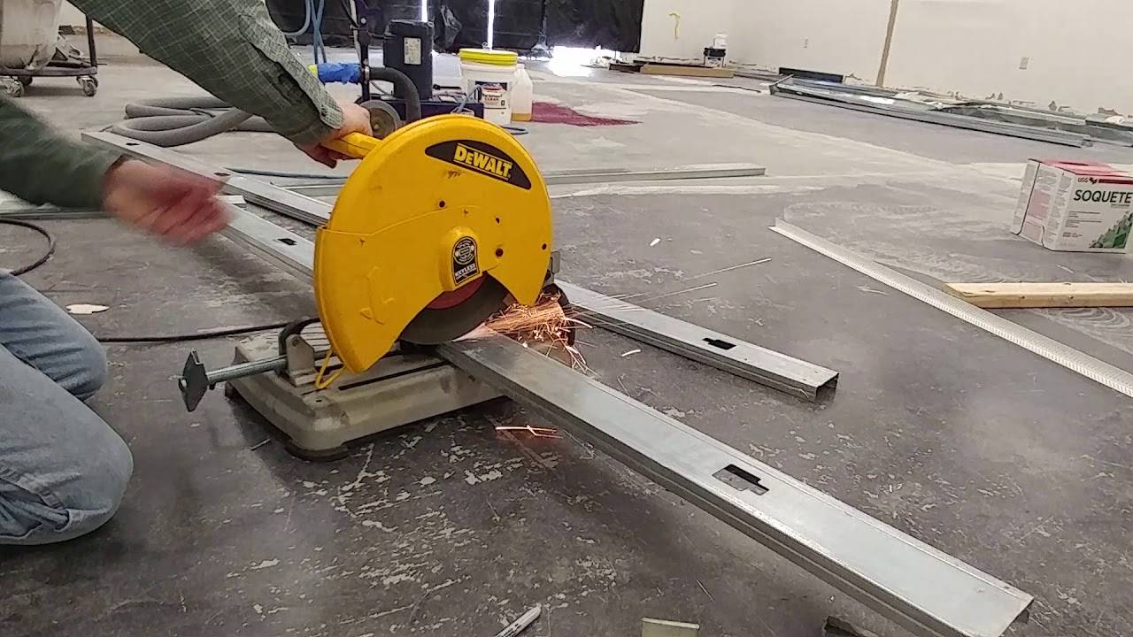 Yellow DeWalt chop saw cutting metal studs.