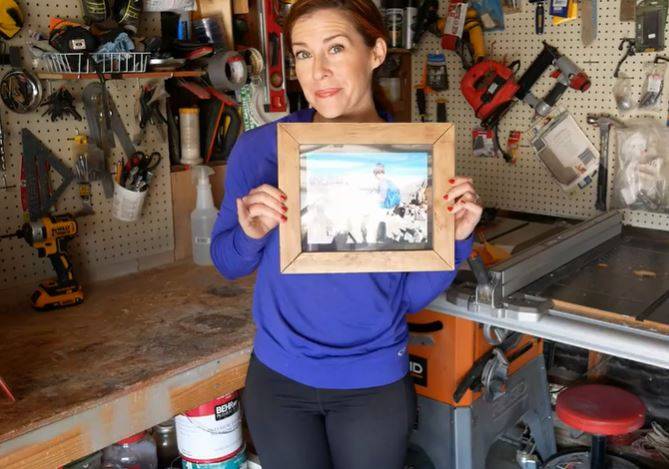 woman holding a wooden picture frame