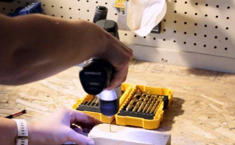 man drilling into a block of wood