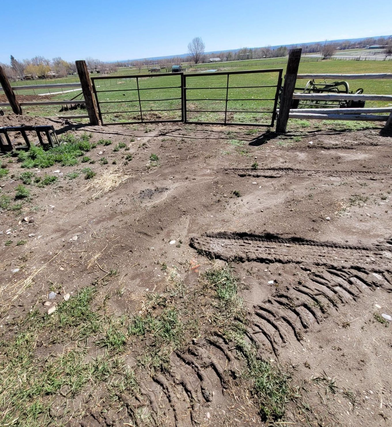 Muddy ground near fencing and gate.